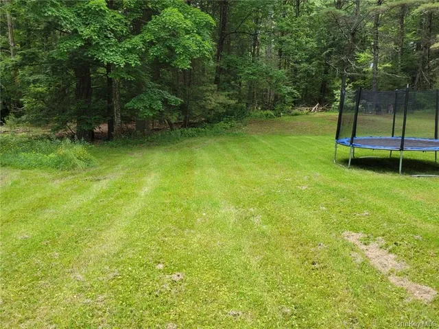 a view of a yard with a wooden fence