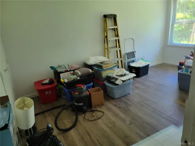 a room with gym equipment and wooden floor