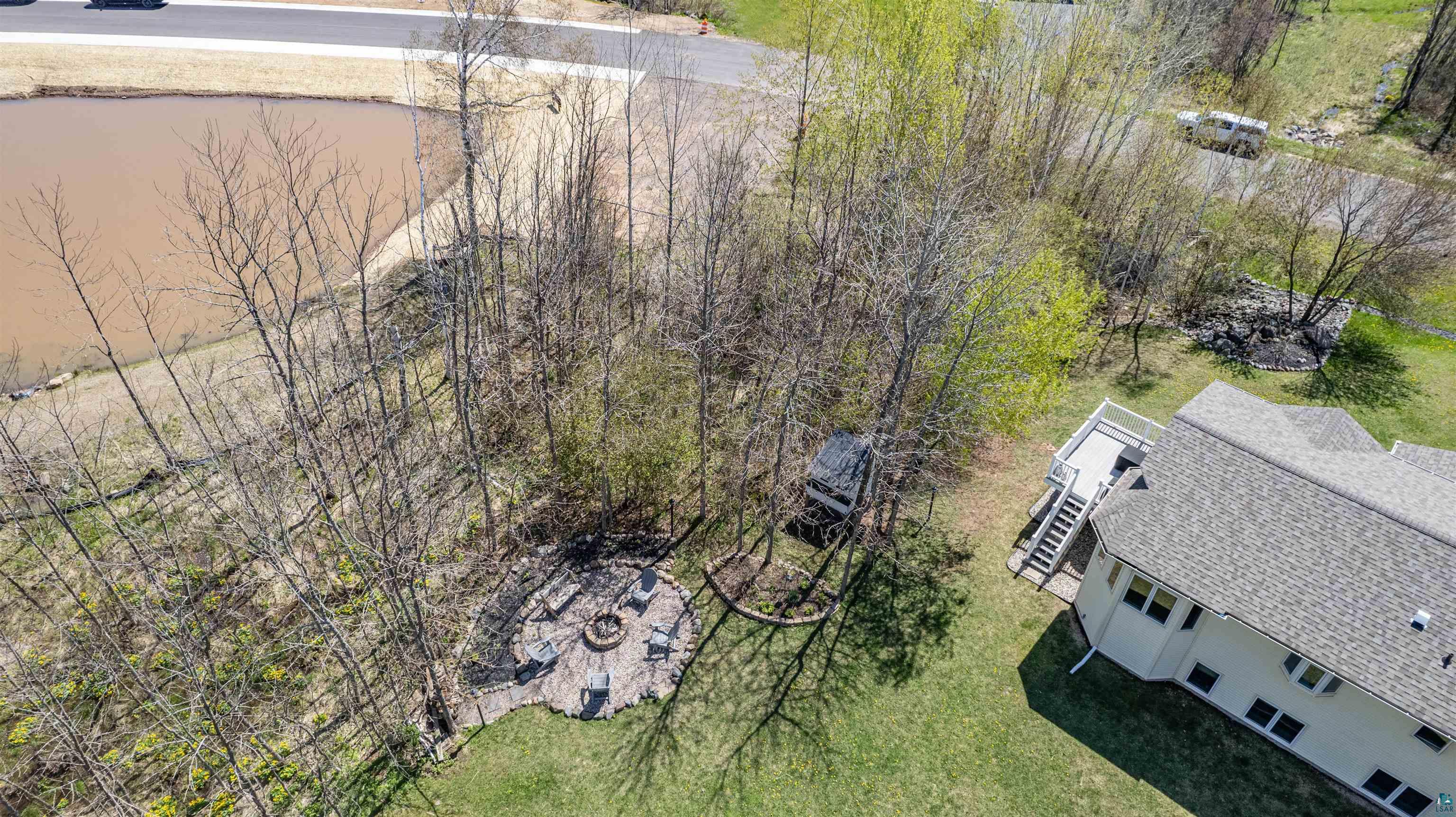 4809 Oak Ridge Drive Hermantown, MN 55811 - Photo 46 of 69 Expansive backyard featuring a stone patio with built-in fire pit, multiple seating areas, and direct access to a multi-level deck