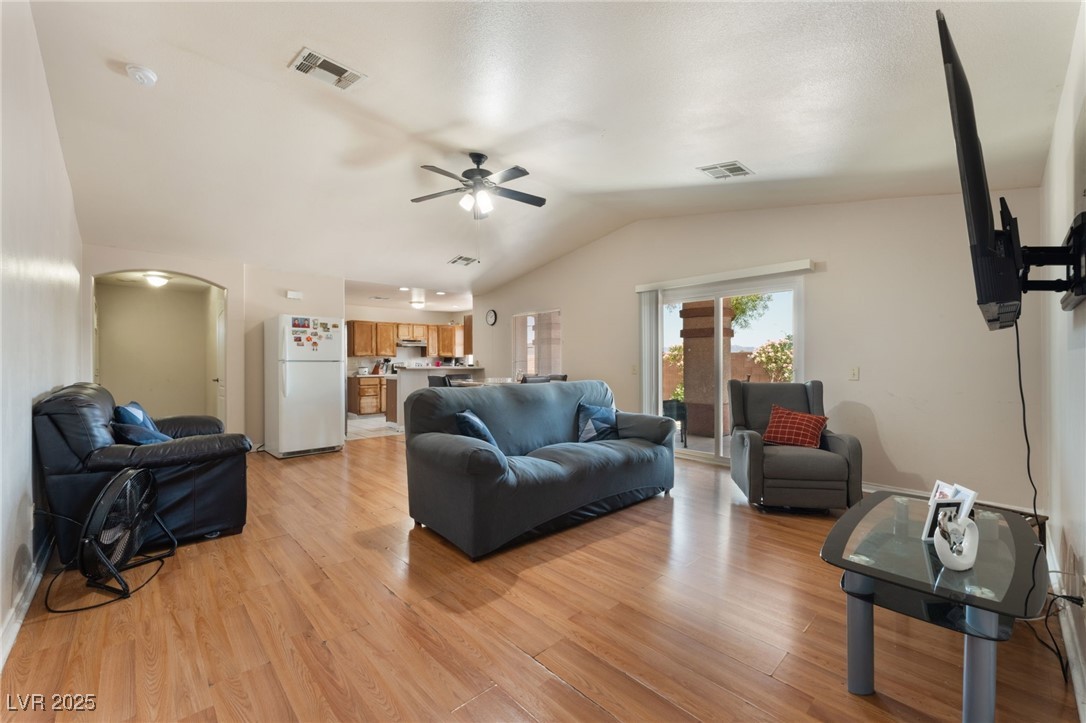 4656 East Desert Inn Road Las Vegas, NV 89121 - Photo 38 of 98 4650 E DI Living area with ceiling fan, vaulted ceiling, arched walkways, and light wood finished floors