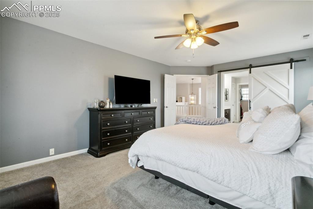 12912 Fishers Island Road Peyton, CO 80831 - Photo 17 of 45 a bedroom with a bed and a flat tv screen on a dresser