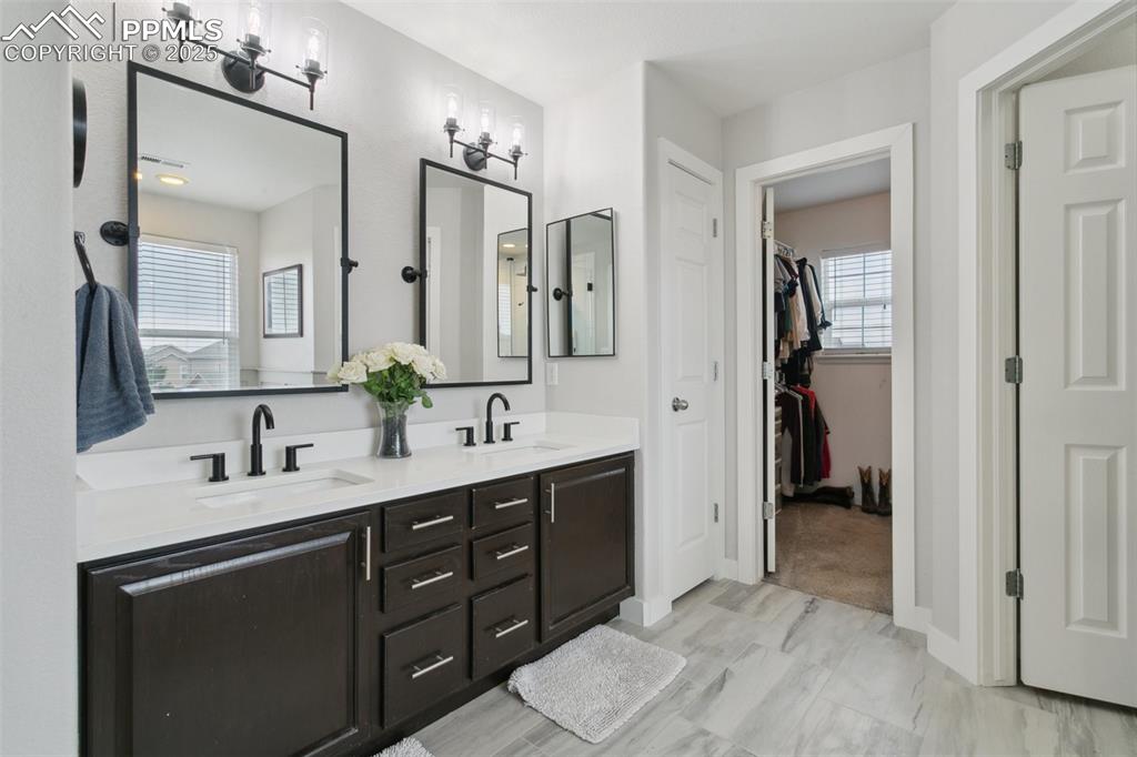 12912 Fishers Island Road Peyton, CO 80831 - Photo 18 of 45 a spacious bathroom with a double vanity sink double and mirror