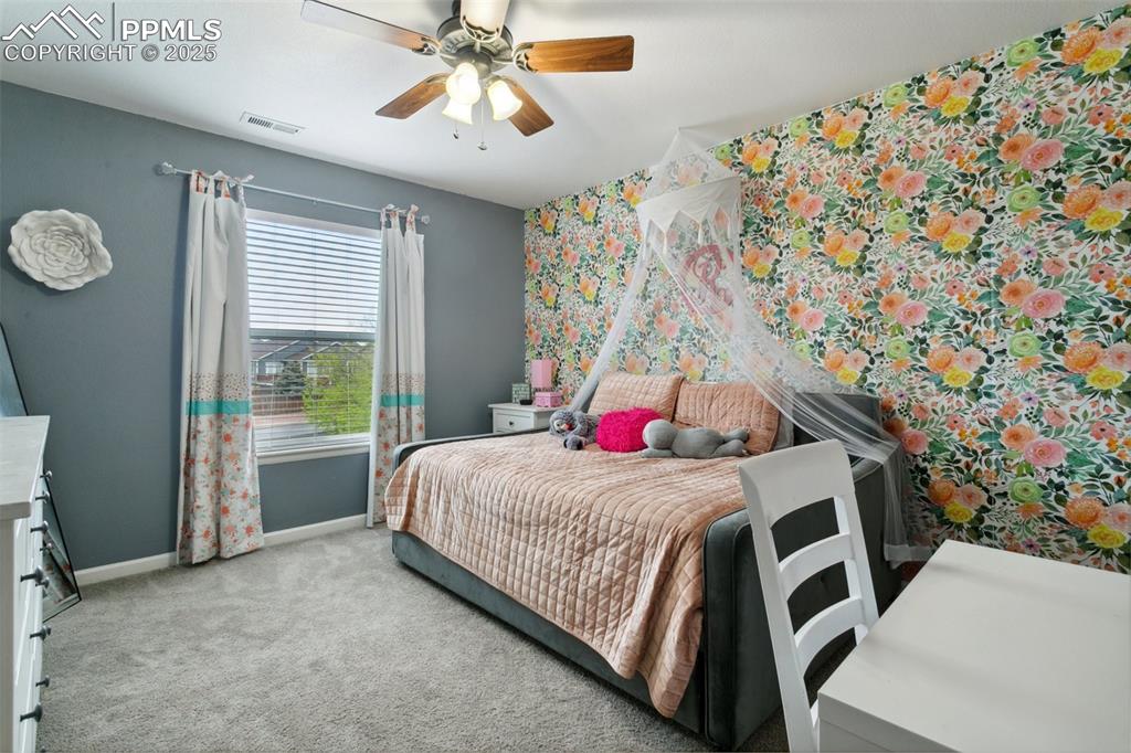 12912 Fishers Island Road Peyton, CO 80831 - Photo 24 of 45 a bedroom with a bed and a chandelier