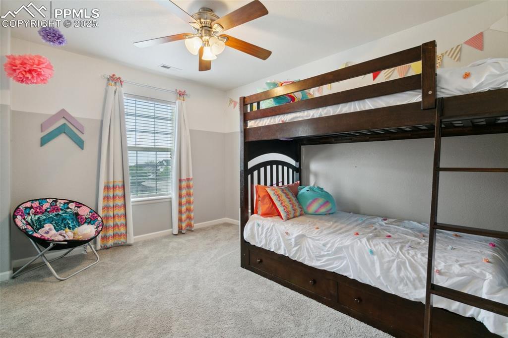 12912 Fishers Island Road Peyton, CO 80831 - Photo 26 of 45 a bedroom with a bed and a chandelier