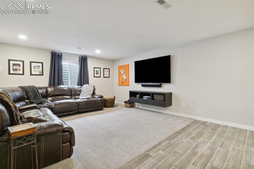 12912 Fishers Island Road Peyton, CO 80831 - Photo 29 of 45 a living room with furniture and a flat screen tv