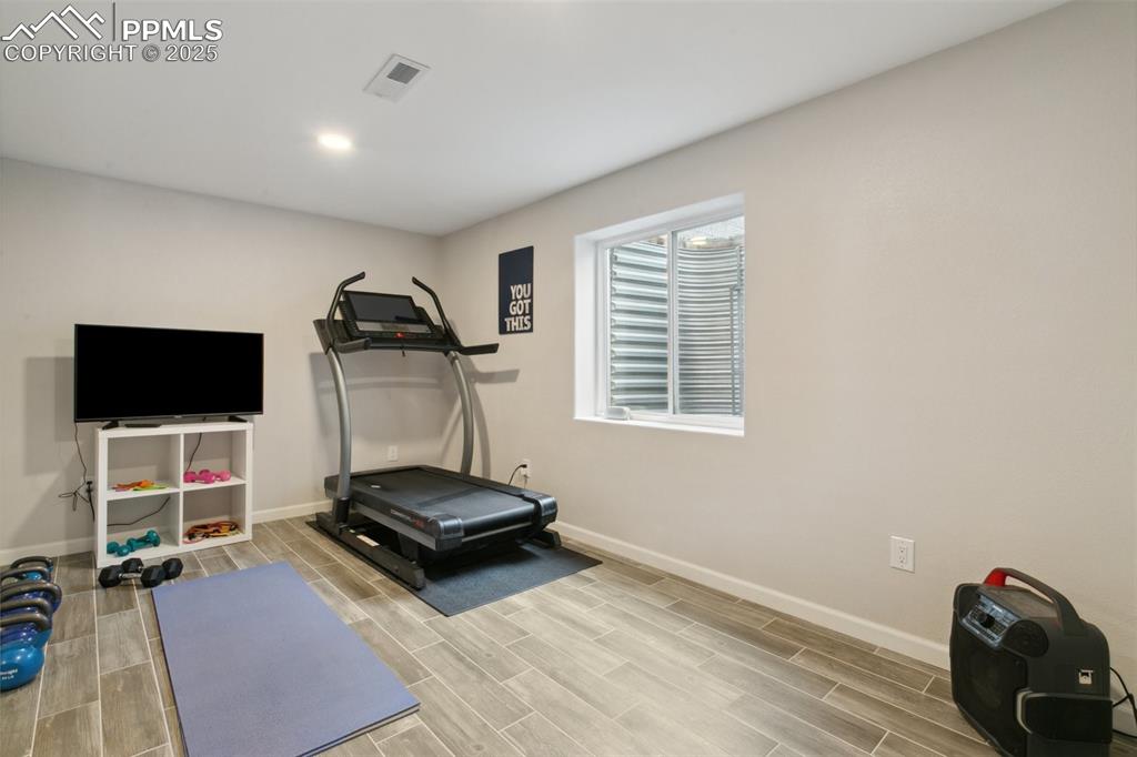 12912 Fishers Island Road Peyton, CO 80831 - Photo 33 of 45 a room with gym equipment and a flat screen tv
