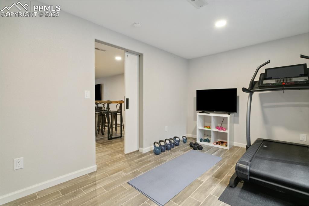 12912 Fishers Island Road Peyton, CO 80831 - Photo 34 of 45 a room with gym equipment and a flat screen tv