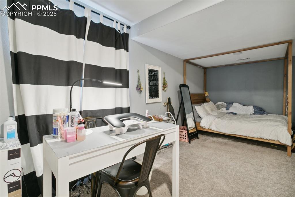 12912 Fishers Island Road Peyton, CO 80831 - Photo 35 of 45 a bedroom with a bed and a table in it