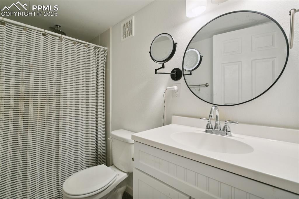 12912 Fishers Island Road Peyton, CO 80831 - Photo 36 of 45 a bathroom with a sink a toilet and a mirror