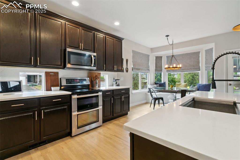 12912 Fishers Island Road Peyton, CO 80831 - Photo 6 of 45 a kitchen with stainless steel appliances a stove sink microwave and cabinets