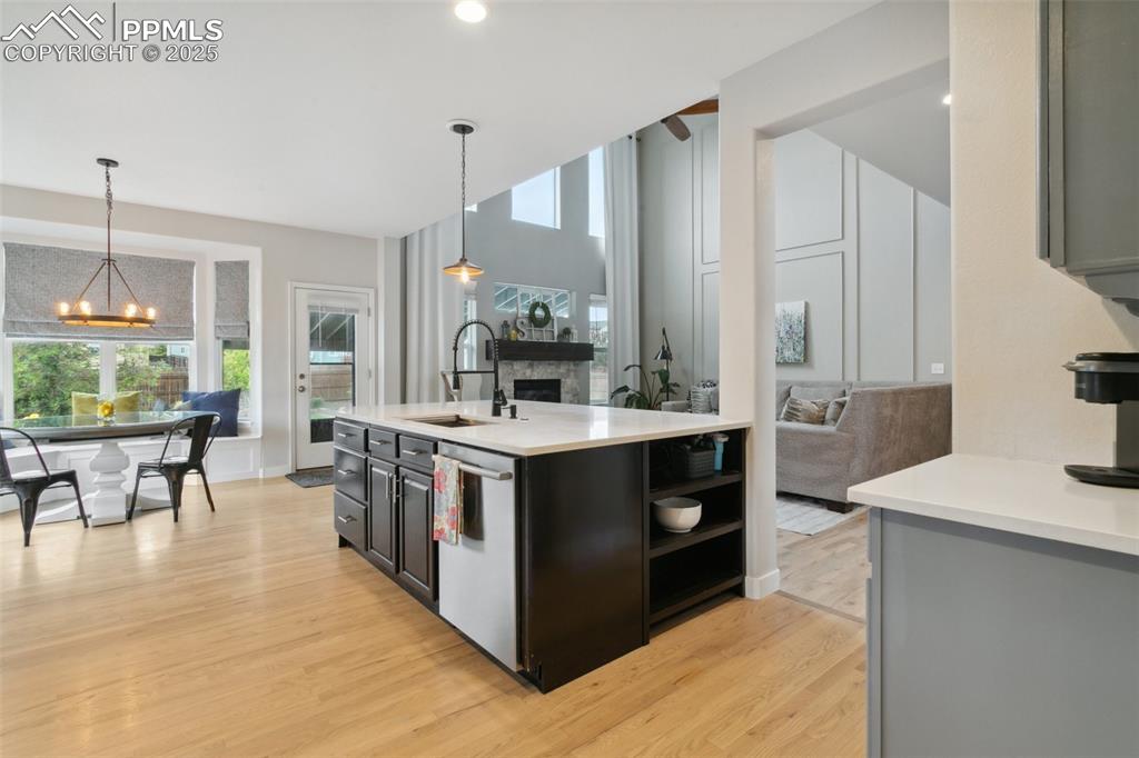 12912 Fishers Island Road Peyton, CO 80831 - Photo 7 of 45 a large kitchen with stainless steel appliances a stove a sink dishwasher a oven and a dining table with wooden floor