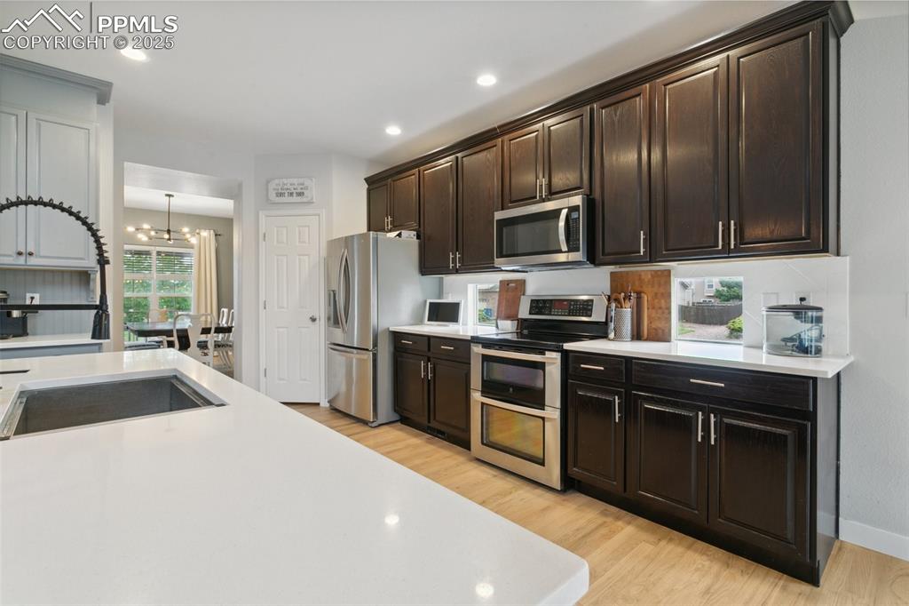 12912 Fishers Island Road Peyton, CO 80831 - Photo 8 of 45 a kitchen with granite countertop stainless steel appliances and wooden cabinets