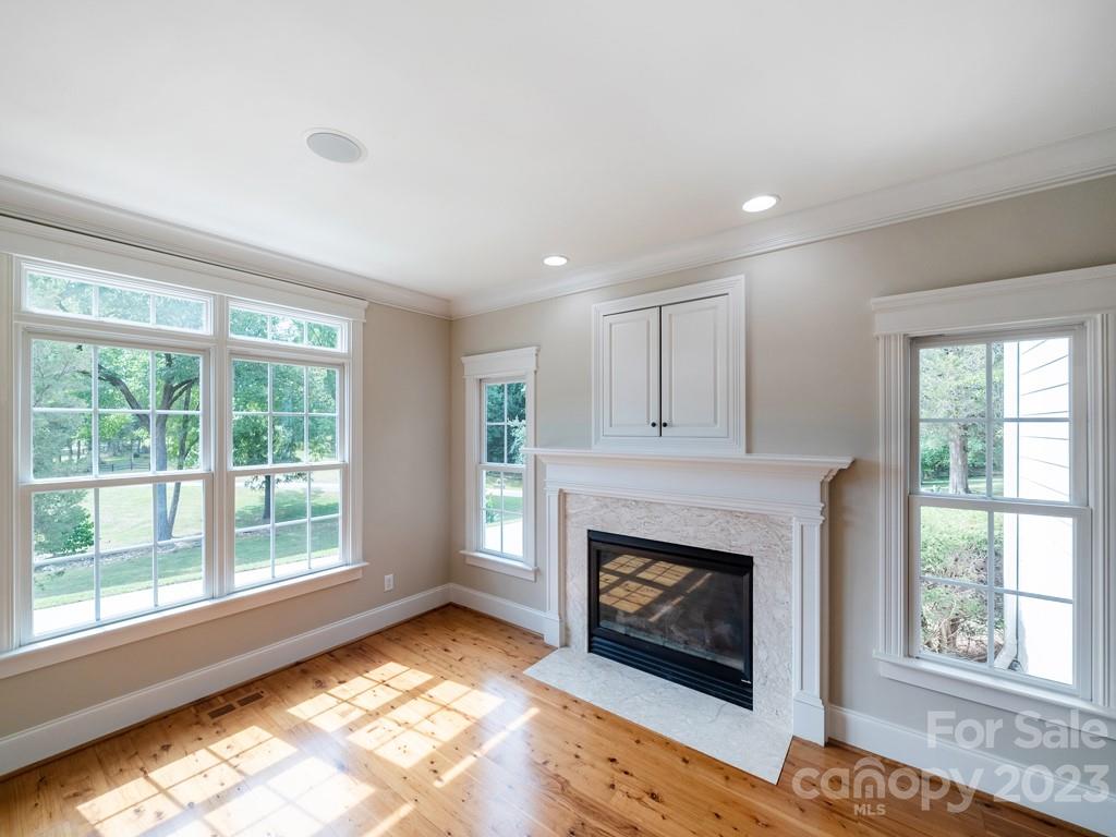 14707 June Washam Road Davidson, NC 28036 - Photo 16 of 48 a living room with a fireplace and a floor to ceiling window