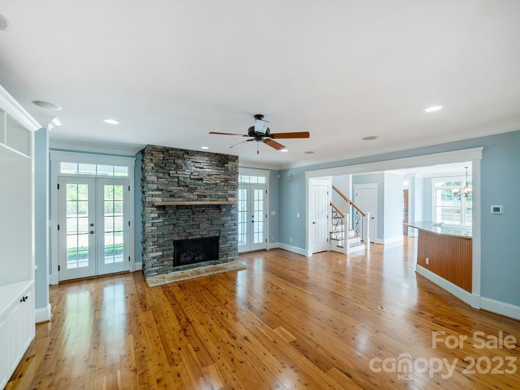 14707 June Washam Road Davidson, NC 28036 - Photo 18 of 48 an empty room with wooden floor fireplace and windows