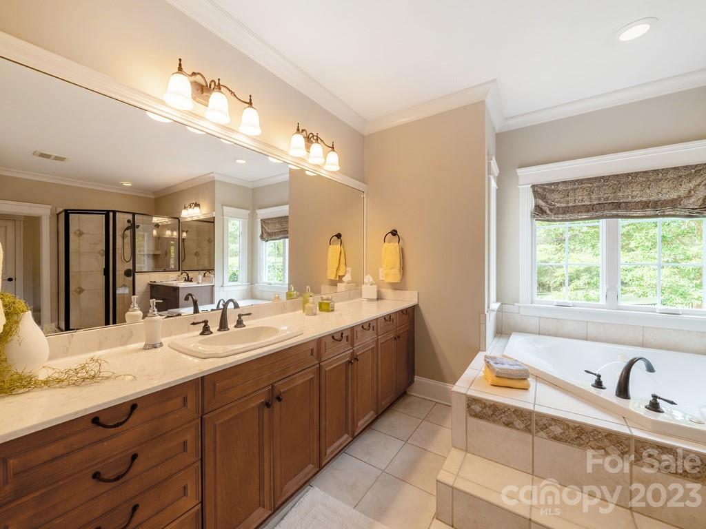 14707 June Washam Road Davidson, NC 28036 - Photo 24 of 48 a bathroom with a tub double vanity sink and mirror
