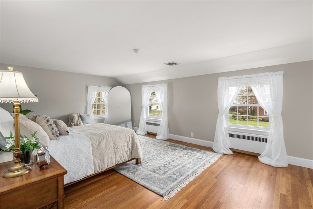 24 Wyndmere Road Milton, MA 02186 - Photo 23 of 37 a bedroom with a bed and a wooden floor