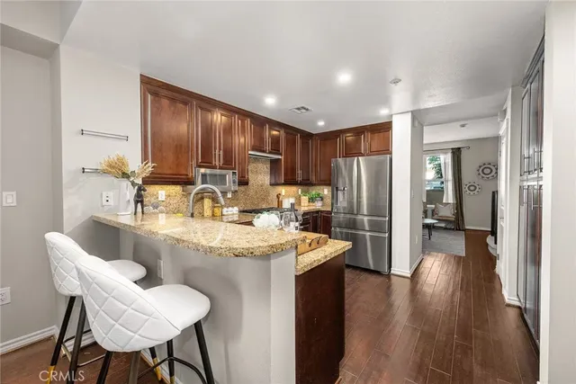 a large kitchen with stainless steel appliances granite countertop a sink refrigerator and cabinets