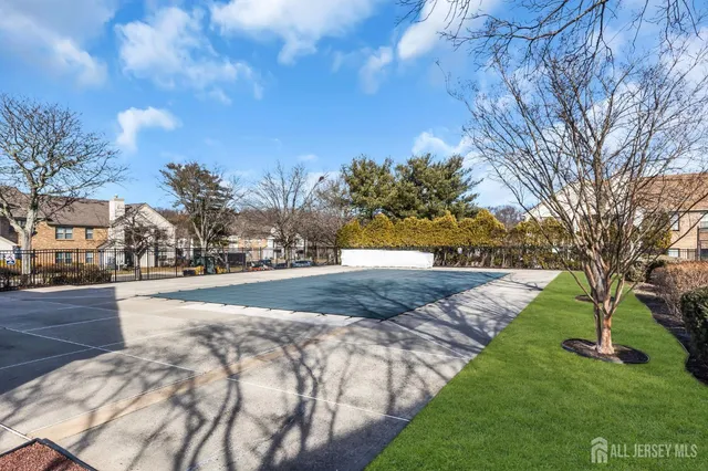 a view of a tennis ground with large trees