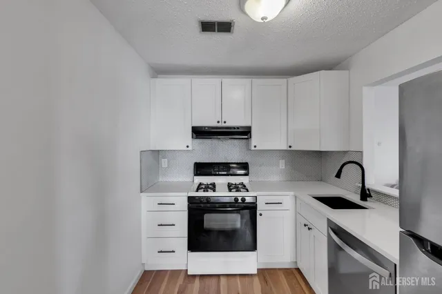a kitchen with appliances a sink and cabinets