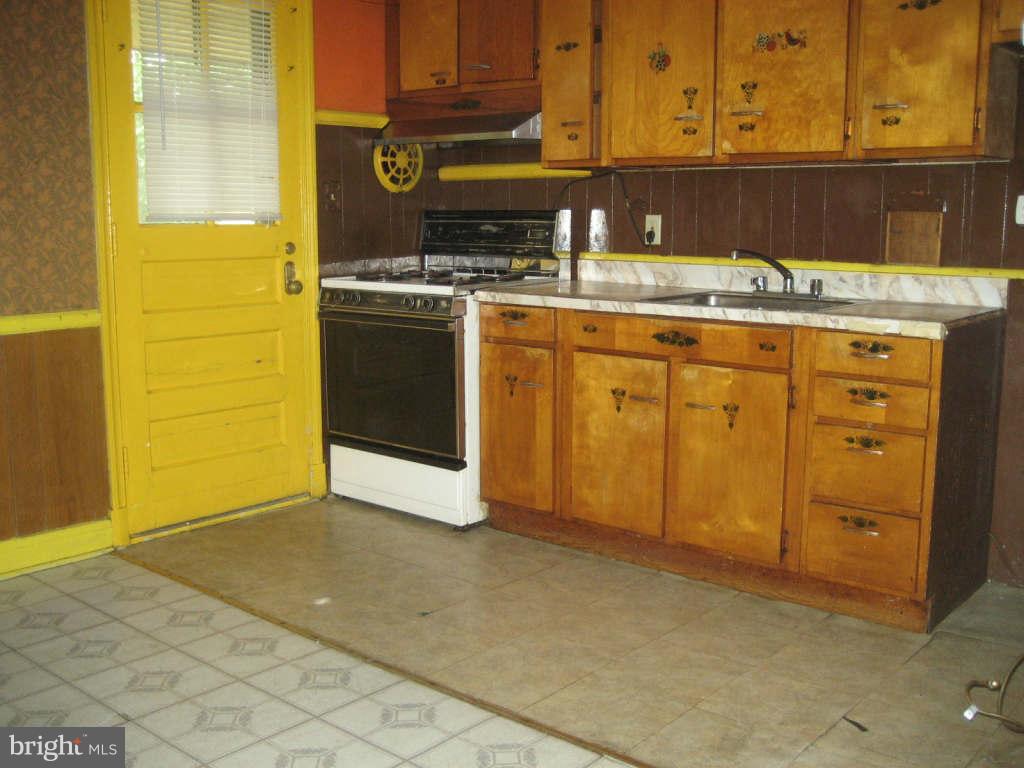 7413 Marston Road Baltimore, MD 21207 - Photo 5 of 16 a kitchen with stainless steel appliances granite countertop a stove a sink and a microwave