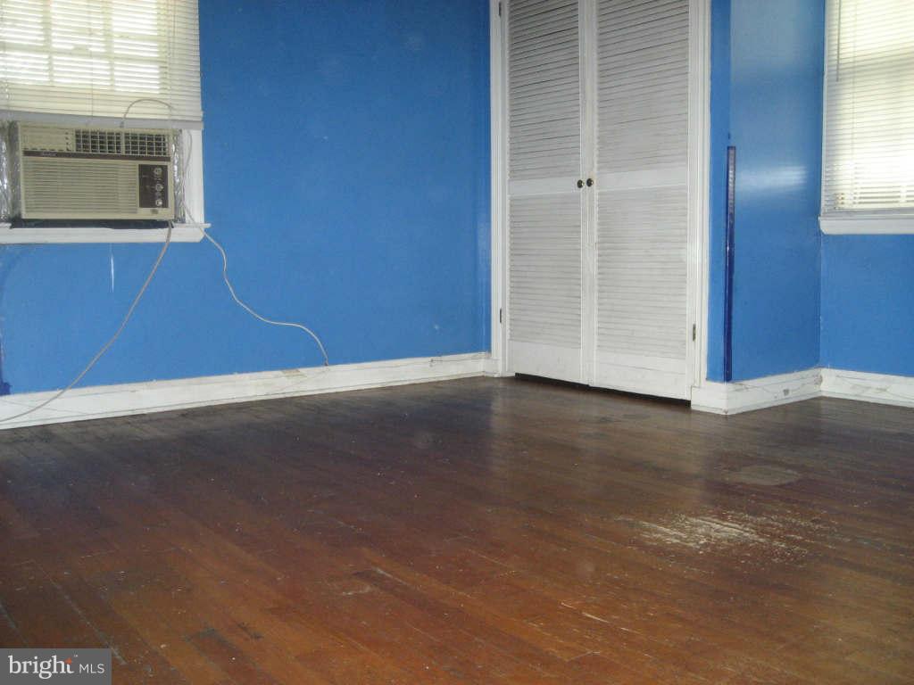 7413 Marston Road Baltimore, MD 21207 - Photo 6 of 16 an empty room with wooden floor and windows