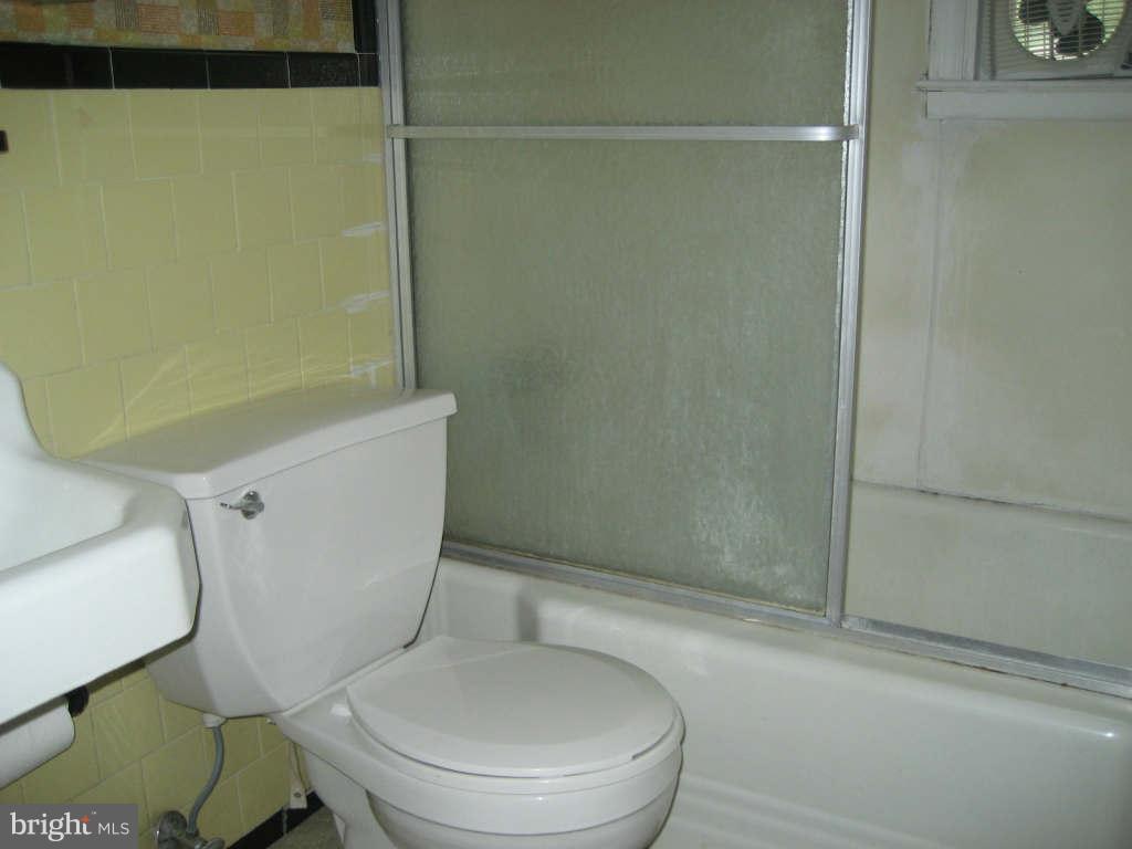 7413 Marston Road Baltimore, MD 21207 - Photo 8 of 16 a white toilet sitting next to a bath tub