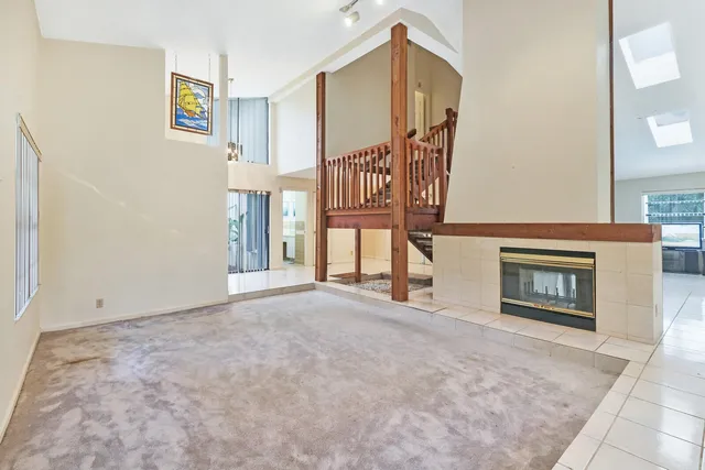 an empty room with windows and fireplace