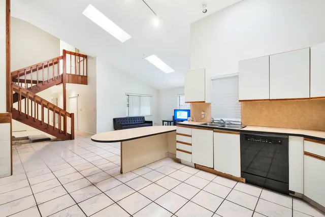 a kitchen with white cabinets a sink and white appliances