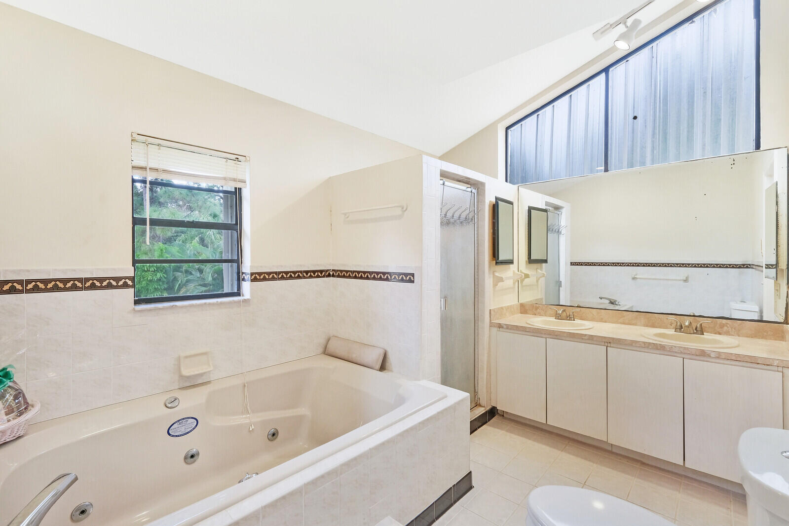 17520 Bridle Court Jupiter, FL 33478 - Photo 29 of 35 a bathroom with a tub a sink and a window