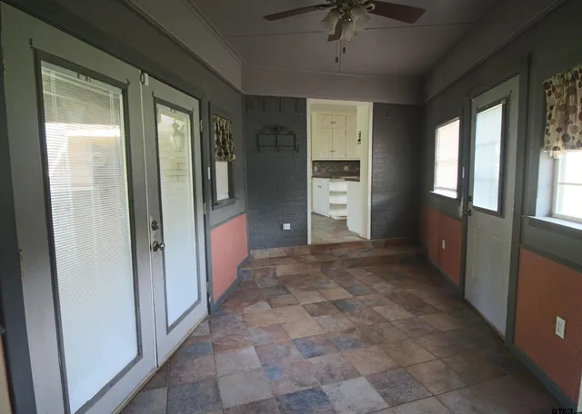 a view of a hallway with windows and brick walls