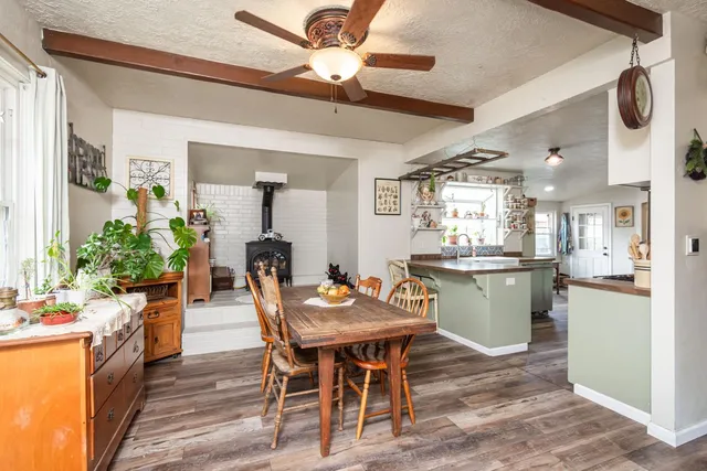 a dining room with furniture a kitchen and chandelier