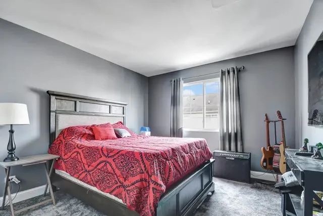 a bedroom with a bed a lamp and a large window