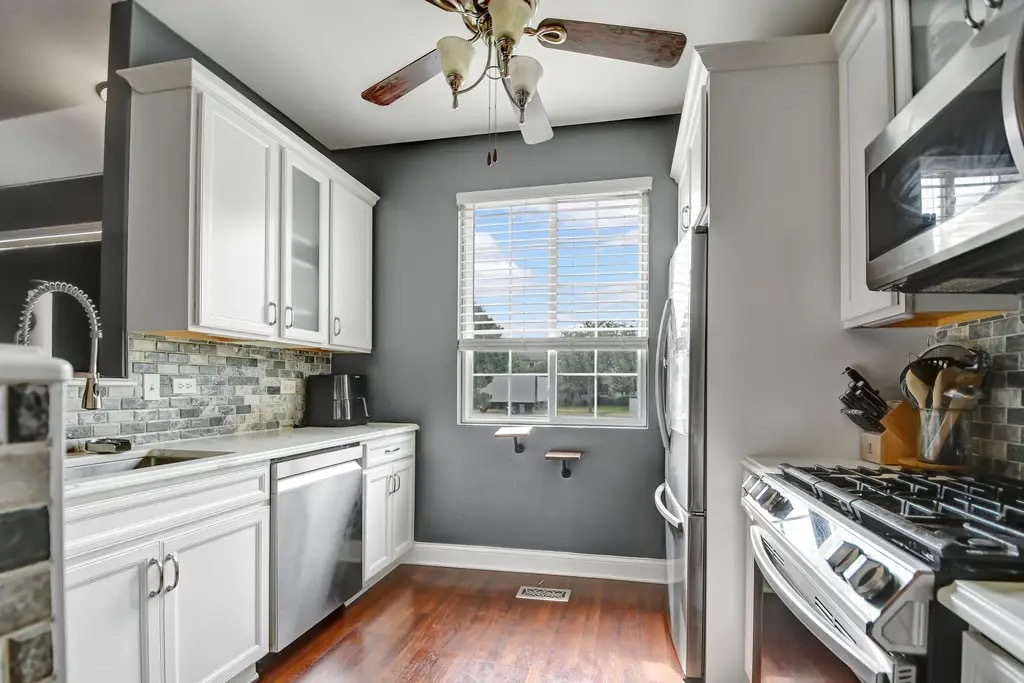142 Azalea Circle Romeoville, IL 60446 - Photo 6 of 15 a kitchen with a stove a sink and wooden floor