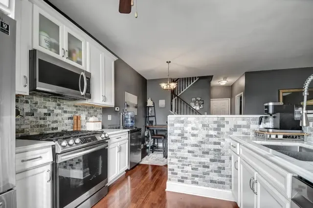 a kitchen with stainless steel appliances a stove microwave and refrigerator