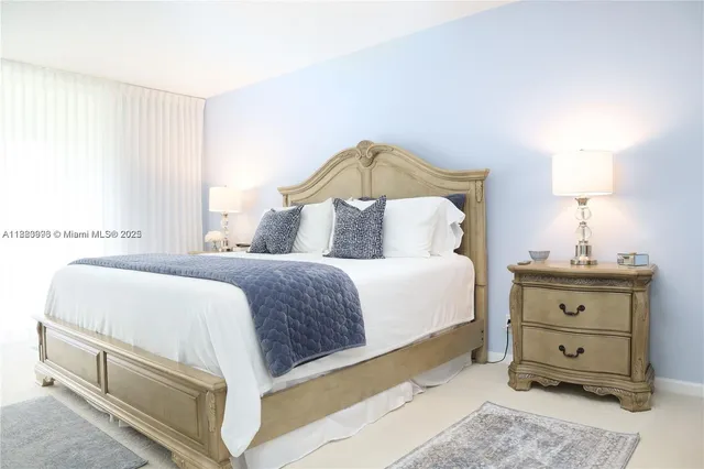 a bedroom with a large bed and a flat tv screen on dresser