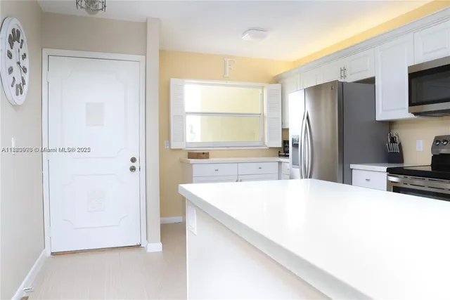 a kitchen with stainless steel appliances a stove microwave and sink