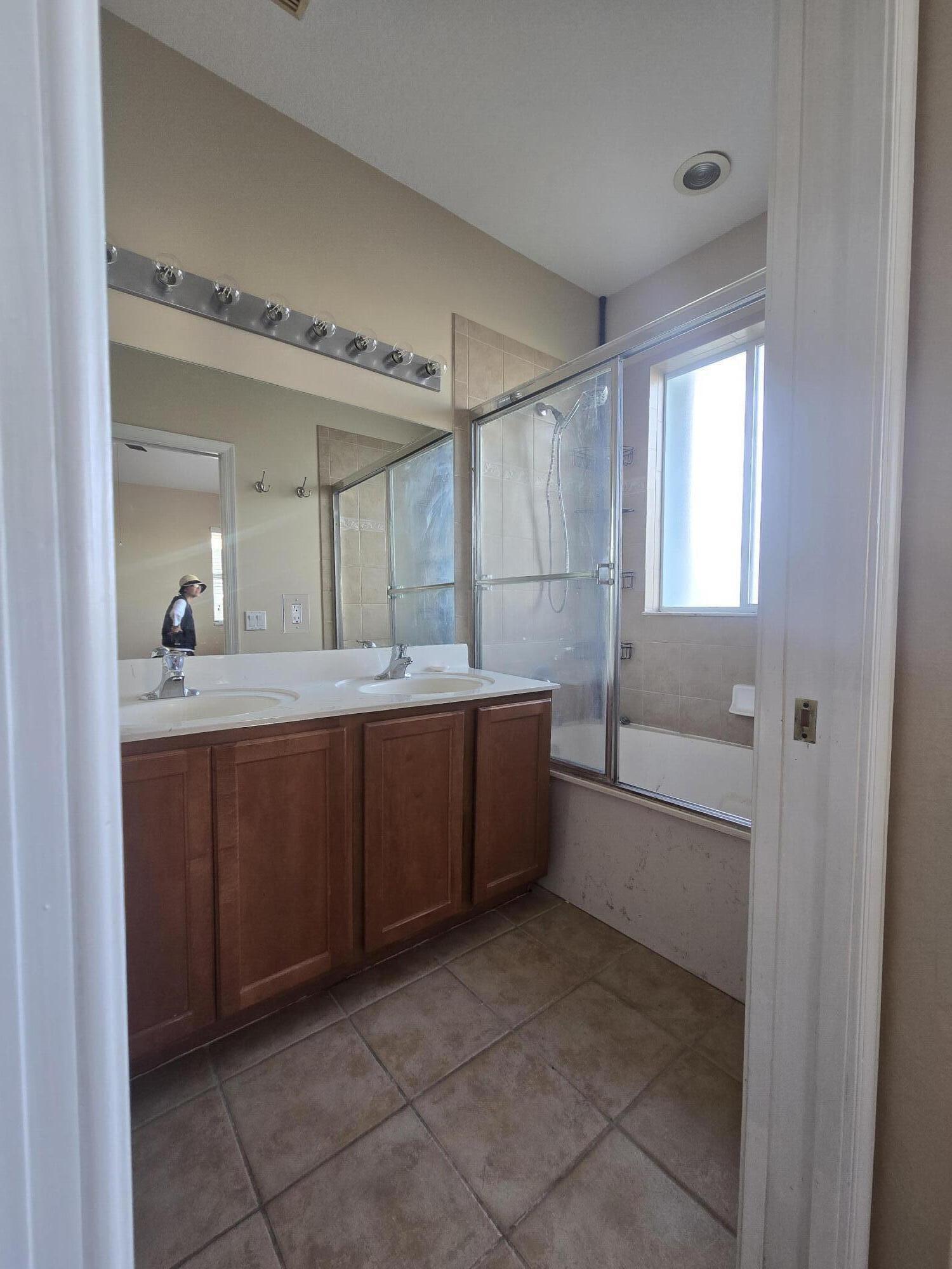 3182 Laurel Ridge Circle Riviera Beach, FL 33404 - Photo 25 of 29 a bathroom with a sink mirror and a bathtub