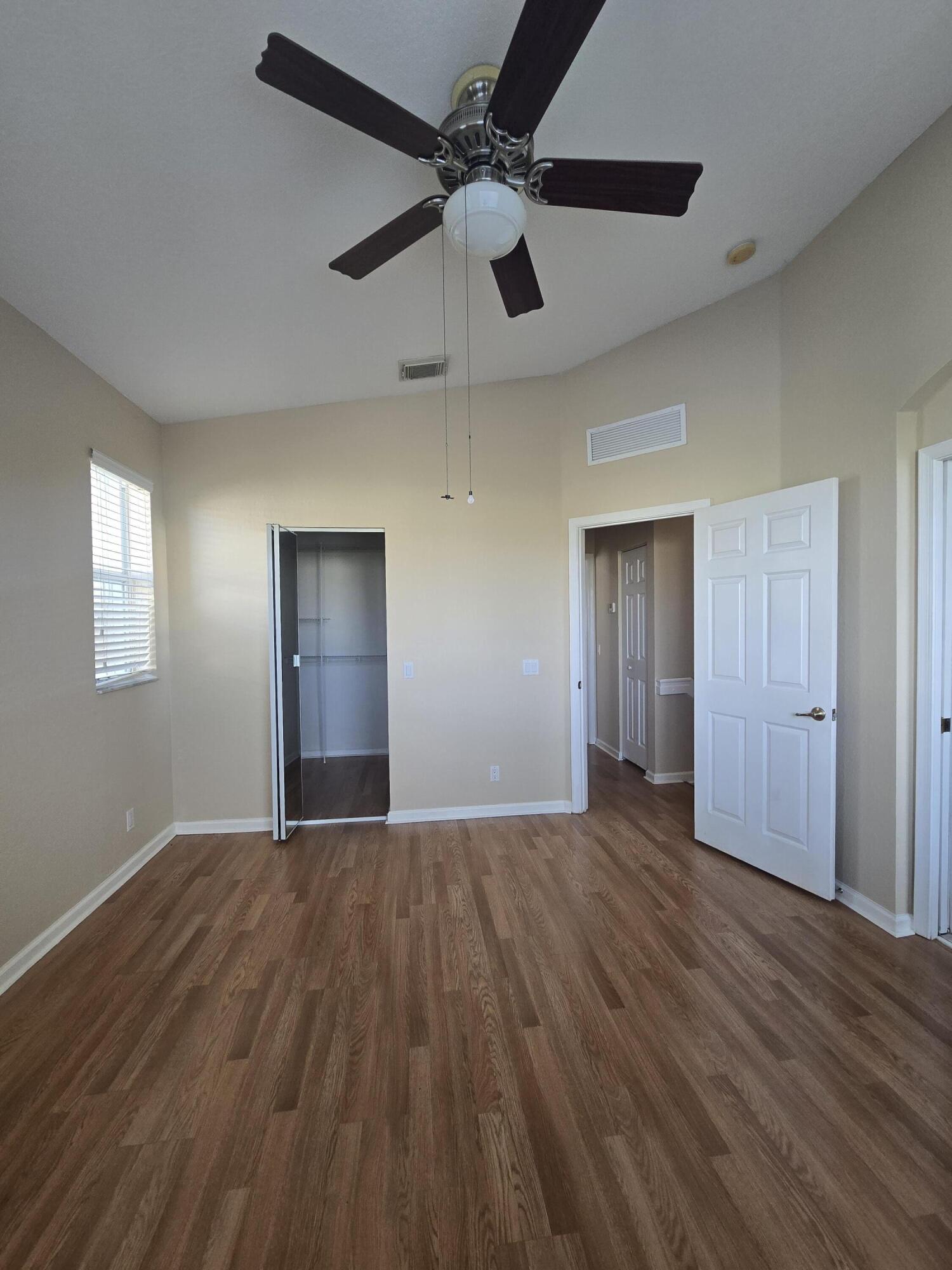 3182 Laurel Ridge Circle Riviera Beach, FL 33404 - Photo 26 of 29 a view of an empty room with window and wooden floor