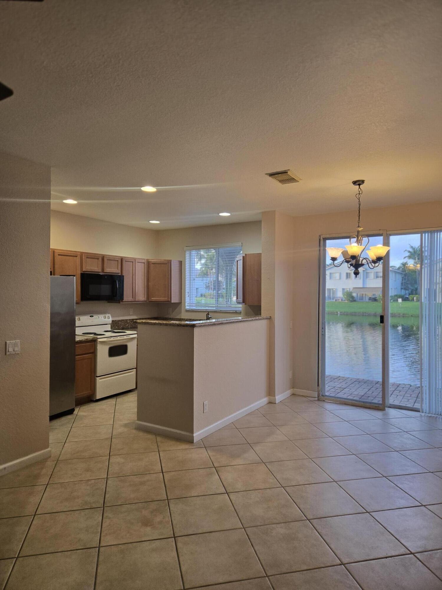 3182 Laurel Ridge Circle Riviera Beach, FL 33404 - Photo 5 of 29 a kitchen with stainless steel appliances kitchen island granite countertop a sink and cabinets