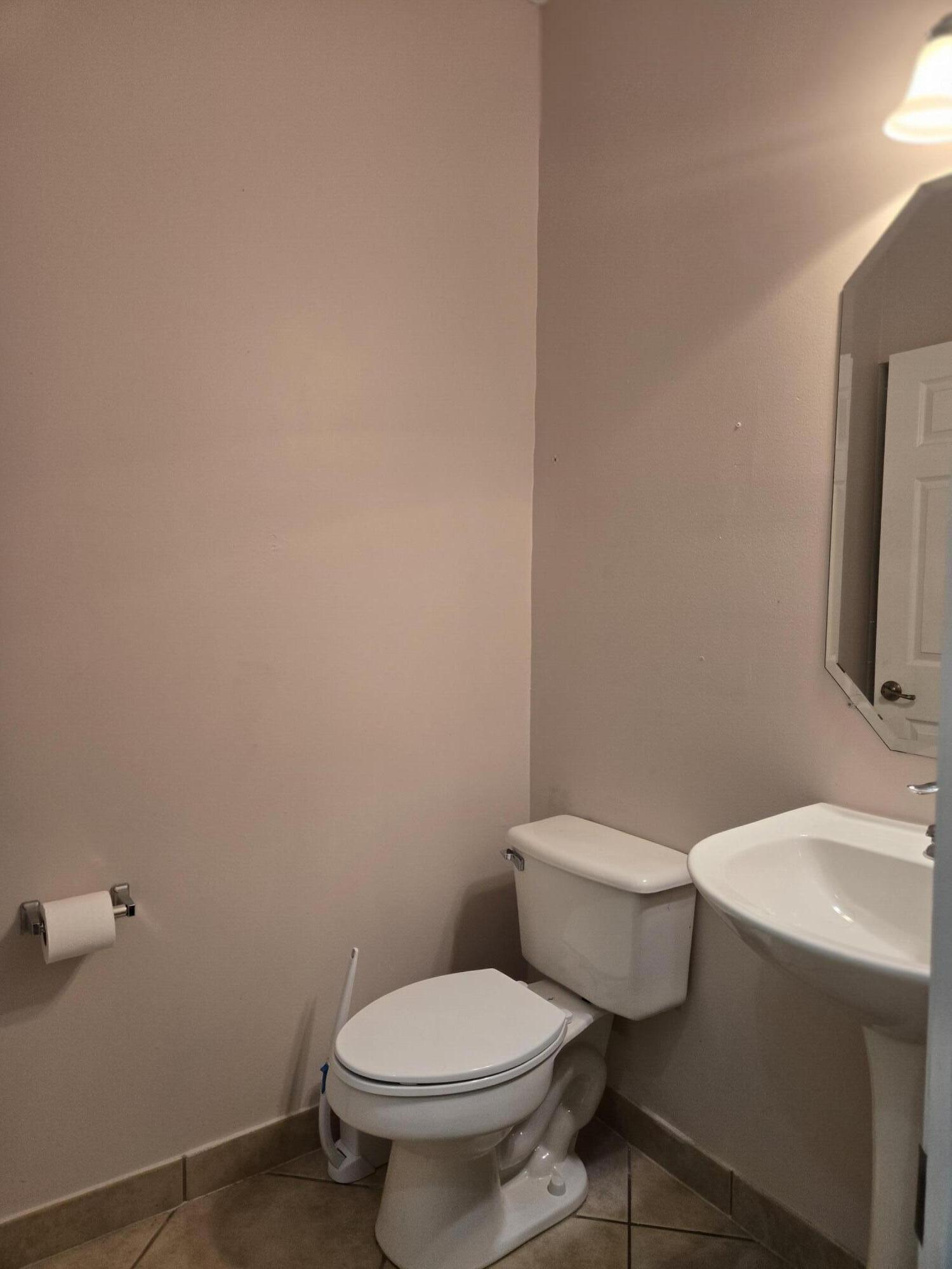 3182 Laurel Ridge Circle Riviera Beach, FL 33404 - Photo 6 of 29 a white toilet sitting next to a bathroom sink