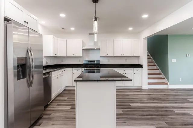 a kitchen with a sink stainless steel appliances and white cabinets