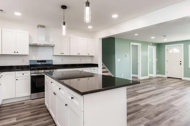 a kitchen with stainless steel appliances granite countertop a stove a sink and a refrigerator