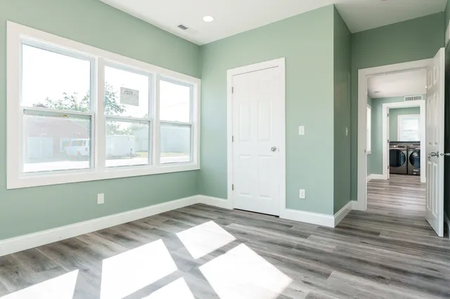 a view of a room with wooden floor and a window