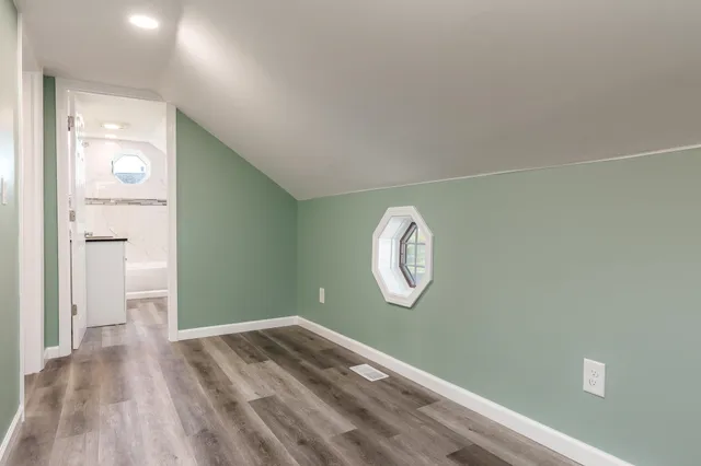 a view of a room with wooden floor and a large window
