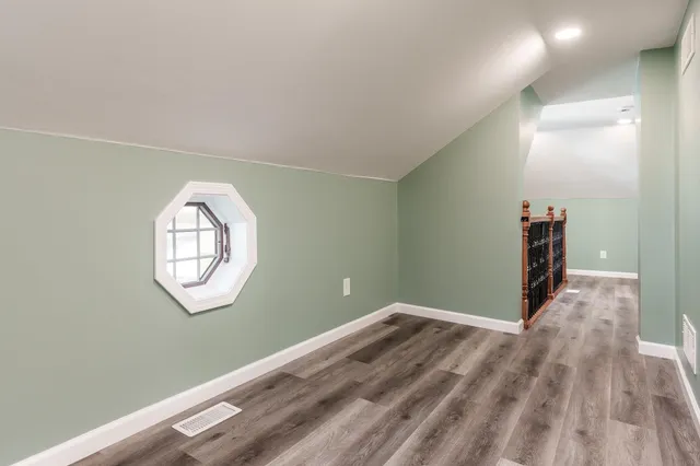 a view of a room with wooden floor and white walls