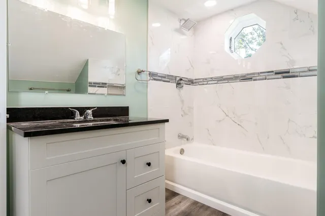 a bathroom with a bathtub a sink and a shower