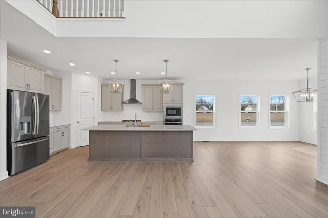 a large kitchen with stainless steel appliances kitchen island a large counter top and a refrigerator
