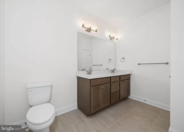 a bathroom with a toilet a sink a vanity and mirror