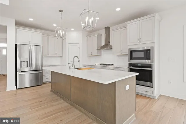 a kitchen with kitchen island a sink stainless steel appliances and cabinets