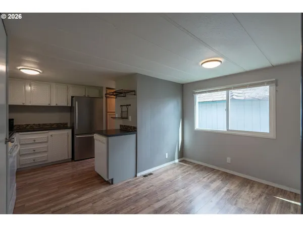 a kitchen with a refrigerator and a stove top oven